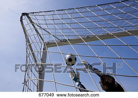 Stock Photo - A goalie reaching to catch a soccer ball. Fotosearch