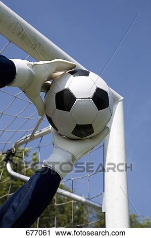 Stock Image - Gloved goalie's hands catching a soccer ball. Fotosearch
