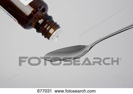 Stock Image - Medicine dropping onto a spoon. Fotosearch