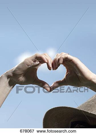 Human hands making the shape of a heart against a blue sky View Large Photo Image Stock Photo - Human hands making the shape of a heart against a blue sky. Fotosearch