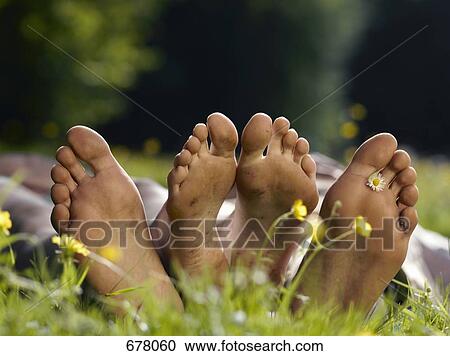 Stock Image - The soles of two people's bare feet, close up. Fotosearch