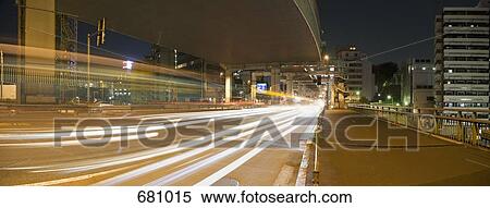 Stock Photography - Traffic passing on a road at night, Tokyo, Japan. Fotosearch
