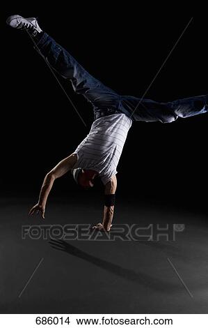 Picture - A B-boy doing a One-handed Freeze breakdance move. Fotosearch