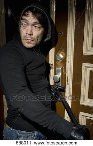 Stock Image - A man burglarizing a home. Fotosearch