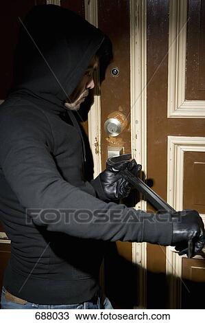 A man burglarizing a home View Large Photo Image Stock Image - A man burglarizing a home. Fotosearch