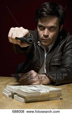 A man holding a gun threateningly View Large Photo Image Stock Photo - A man holding a gun threateningly. Fotosearch