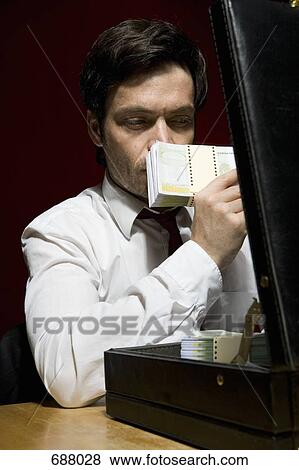 A man smelling a stack of money View Large Photo Image Stock Photo - A man smelling a stack of money. Fotosearch