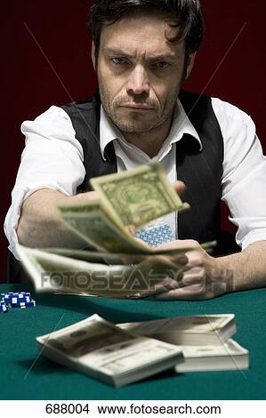 A man throwing money into the pot at a high stakes poker game View Large Photo Image Picture - A man throwing money into the pot at a high stakes poker game. Fotosearch