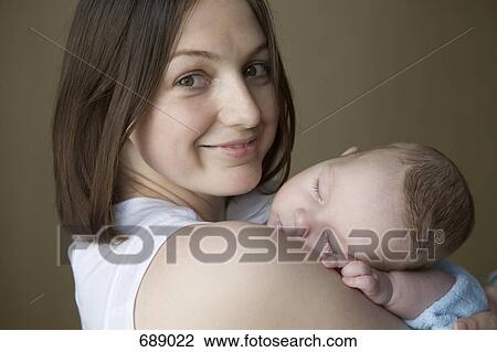 A mother holding a sleeping baby View Large Photo Image Stock Image - A mother holding a sleeping baby. Fotosearch