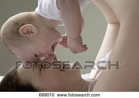 A mother lifting her baby in the air View Large Photo Image Stock Image - A mother lifting her baby in the air. Fotosearch