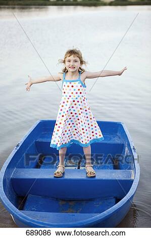 Stock Photograph - A young girl standing on a boat. Fotosearch