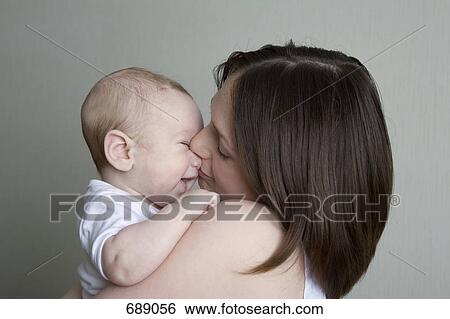 Portrait of a mother kissing a baby View Large Photo Image Stock Photograph - Portrait of a mother kissing a baby. Fotosearch