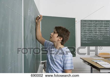 A pre-adolescent boy standing at a chalkboard View Large Photo Image Stock Image - A pre-adolescent boy standing at a chalkboard. Fotosearch