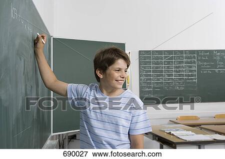 A pre-adolescent boy standing at a chalkboard View Large Photo Image Stock Photo - A pre-adolescent boy standing at a chalkboard. Fotosearch