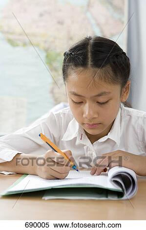 A pre-adolescent girl studying in a classroom View Large Photo Image Stock Photography - A pre-adolescent girl studying in a classroom. Fotosearch