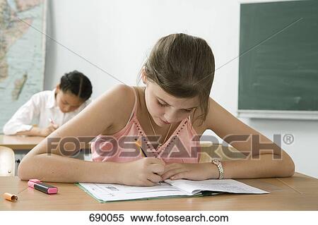 A pre-adolescent girl studying in a classroom View Large Photo Image Stock Photography - A pre-adolescent girl studying in a classroom. Fotosearch