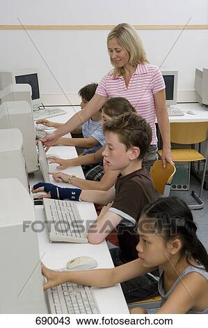 A teacher and four pre-adolescent children in a computer lab View Large Photo Image Stock Image - A teacher and four pre-adolescent children in a computer lab. Fotosearch