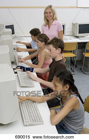 A teacher and four pre-adolescent children in a computer lab View Large Photo Image Stock Photography - A teacher and four pre-adolescent children in a computer lab. Fotosearch