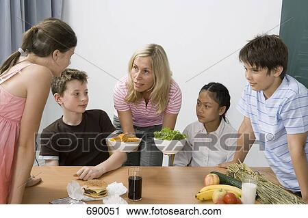 Stock Image - A teacher and four students learning about nutrition. Fotosearch