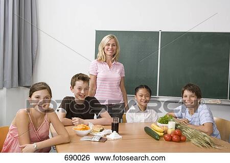 A teacher and four students learning about nutrition View Large Photo Image Stock Photograph - A teacher and four students learning about nutrition. Fotosearch
