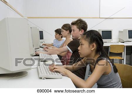 Four pre-adolescent children in a computer lab View Large Photo Image Picture - Four pre-adolescent children in a computer lab. Fotosearch