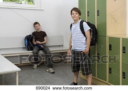 Two pre-adolescent boys relaxing in a locker bay View Large Photo Image Picture - Two pre-adolescent boys relaxing in a locker bay. Fotosearch