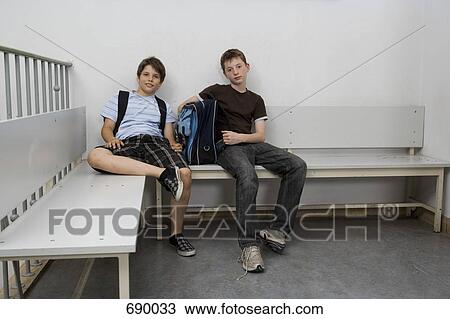 Two pre-adolescent boys sitting on a bench View Large Photo Image Stock Image - Two pre-adolescent boys sitting on a bench. Fotosearch