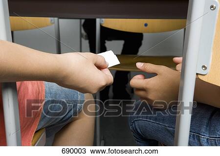 Two pre-adolescent girls passing a note View Large Photo Image Stock Image - Two pre-adolescent girls passing a note. Fotosearch
