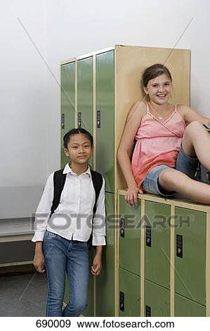 Stock Photo - Two pre-adolescent girls relaxing in a locker bay. Fotosearch
