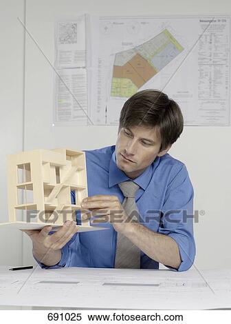 An architect examining an architectural model View Large Photo Image Stock Photography - An architect examining an architectural model. Fotosearch