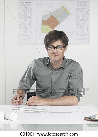 An architect sitting at his desk View Large Photo Image Stock Image - An architect sitting at his desk. Fotosearch