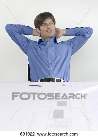 An architect sitting at his desk View Large Photo Image Stock Image - An architect sitting at his desk. Fotosearch