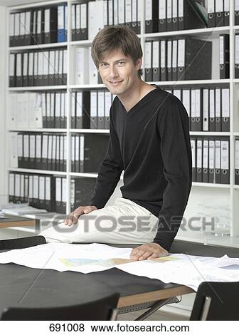 An architect sitting on desk View Large Photo Image Stock Photo - An architect sitting on desk. Fotosearch