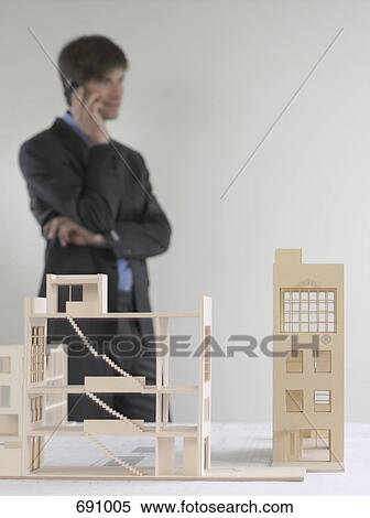 Architectural models and a business man standing in the background View Large Photo Image Stock Photography - Architectural models and a business man standing in the background. Fotosearch