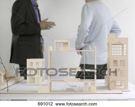 Two people discussing behind architectural models View Large Photo Image Stock Image - Two people discussing behind architectural models. Fotosearch