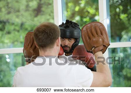 A boxer working with a trainer View Large Photo Image Stock Photo - A boxer working with a trainer. Fotosearch