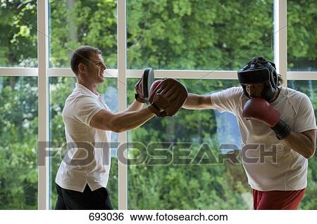 A boxer working with a trainer View Large Photo Image Stock Photograph - A boxer working with a trainer. Fotosearch