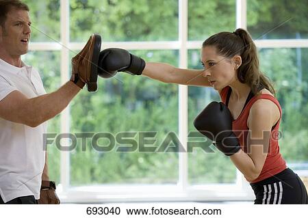 A female boxer working with a trainer View Large Photo Image Stock Image - A female boxer working with a trainer. Fotosearch