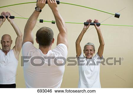Stock Photograph - A fitness instructor teaching a Aerobic Flex Bar class. Fotosearch