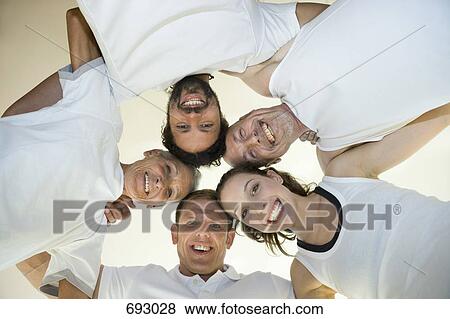 A group of people with their arms around each other, directly below View Large Photo Image Stock Photo - A group of people with their arms around each other, directly below. Fotosearch