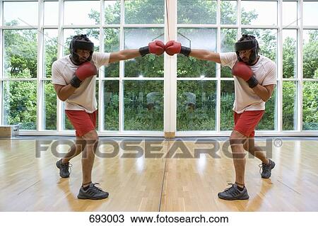 A man boxing his mirrored reflection View Large Photo Image Stock Image - A man boxing his mirrored reflection. Fotosearch