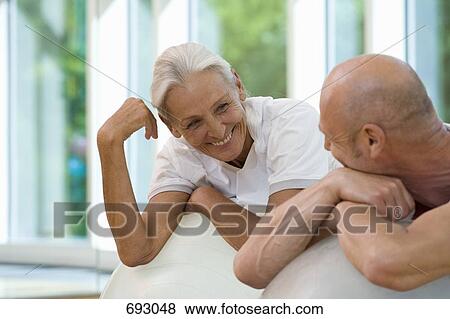 A mature man and a senior woman leaning on exercise balls View Large Photo Image Stock Photo - A mature man and a senior woman leaning on exercise balls. Fotosearch