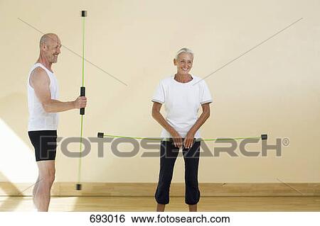 Stock Photograph - A mature man and a senior woman using aerobic flex bars. Fotosearch