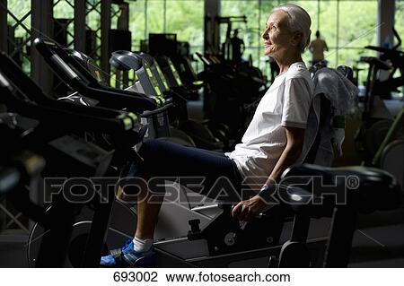 A senior woman on a stationary bike View Large Photo Image Stock Image - A senior woman on a stationary bike. Fotosearch