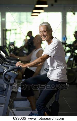 A senior woman on a stationary bike View Large Photo Image Stock Photography - A senior woman on a stationary bike. Fotosearch