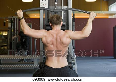 A weightlifter using a lateral pull-down weight machine View Large Photo Image Stock Photo - A weightlifter using a lateral pull-down weight machine. Fotosearch