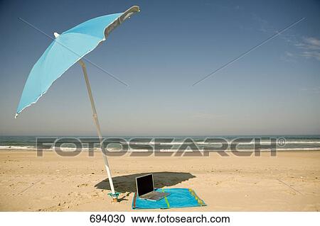 A laptop lying on a beach towel on a beach View Large Photo Image Stock Image - A laptop lying on a beach towel on a beach. Fotosearch