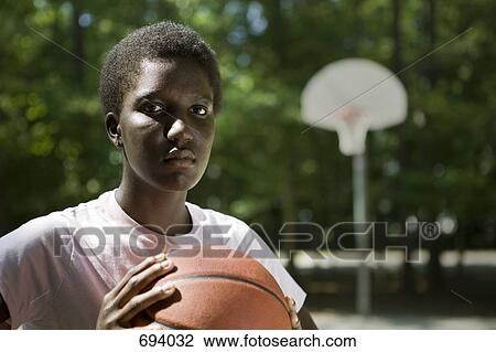 A young serious woman holding a basketball View Large Photo Image Stock Image - A young serious woman holding a basketball. Fotosearch