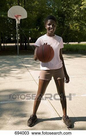 A young woman dribbling a basketball, outdoors View Large Photo Image Stock Image - A young woman dribbling a basketball, outdoors. Fotosearch