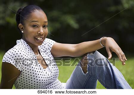 A young woman relaxing in a yard View Large Photo Image Stock Photograph - A young woman relaxing in a yard. Fotosearch